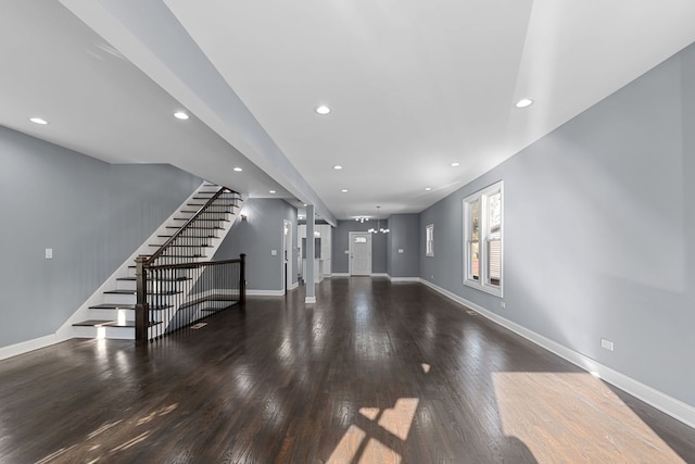 unfurnished living room featuring dark hardwood / wood-style floors and a chandelier