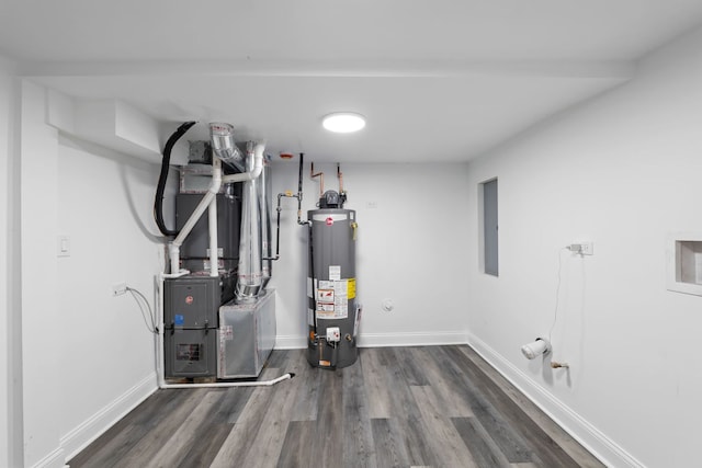 utility room with heating unit, electric panel, and gas water heater