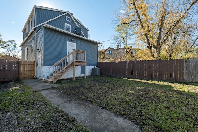 back of property with a lawn and central air condition unit