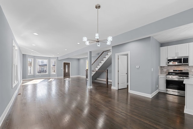 unfurnished living room with dark hardwood / wood-style flooring and an inviting chandelier