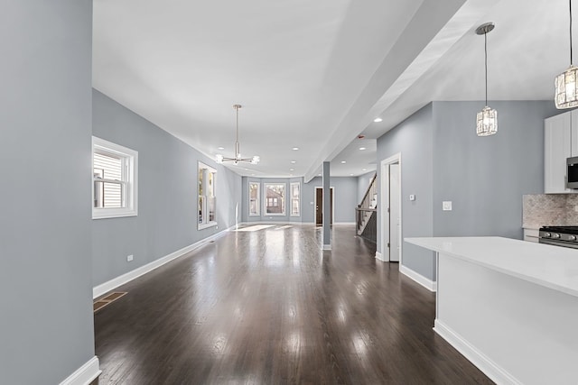 living room with dark hardwood / wood-style floors and an inviting chandelier