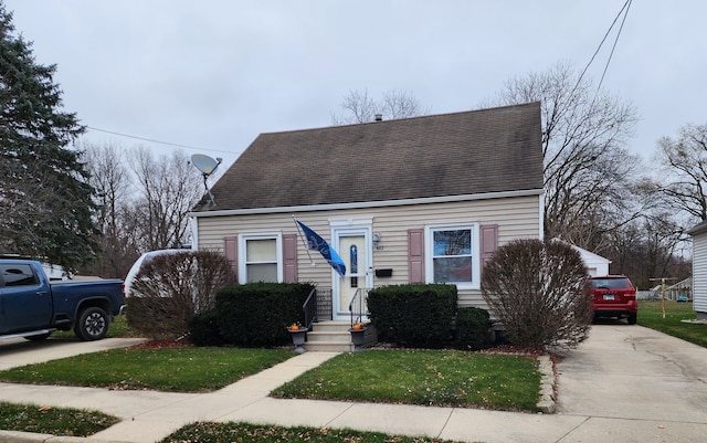 cape cod home featuring a front yard