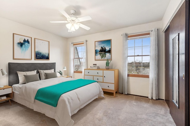 carpeted bedroom with multiple windows and ceiling fan