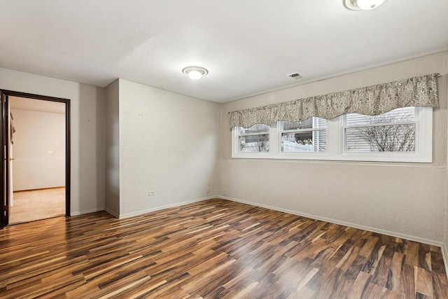 spare room featuring dark hardwood / wood-style flooring