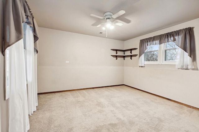 carpeted spare room featuring ceiling fan