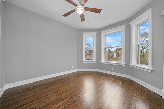 unfurnished room with plenty of natural light, ceiling fan, and dark wood-type flooring