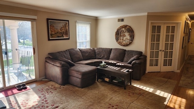 living room featuring hardwood / wood-style flooring, crown molding, and french doors