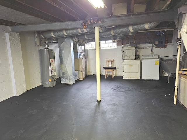 basement featuring electric panel, sink, independent washer and dryer, water heater, and heating unit