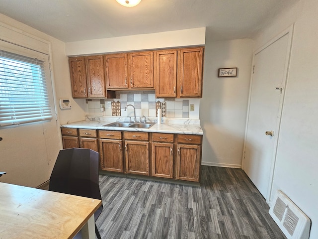 kitchen with decorative backsplash, dark wood-type flooring, and sink