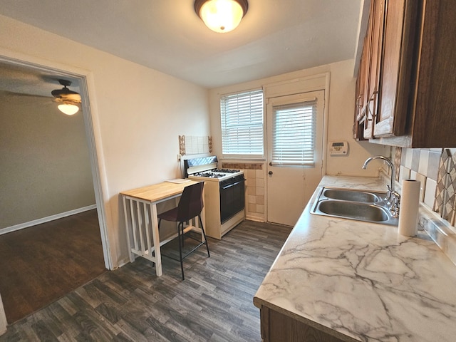 kitchen with white range oven, dark hardwood / wood-style floors, and sink