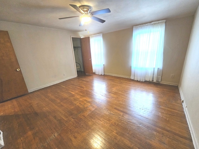 empty room featuring dark hardwood / wood-style flooring and ceiling fan