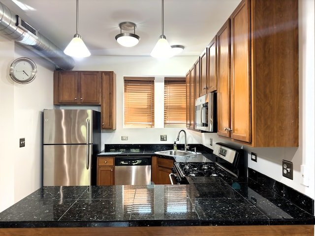 kitchen with hanging light fixtures, kitchen peninsula, sink, and stainless steel appliances