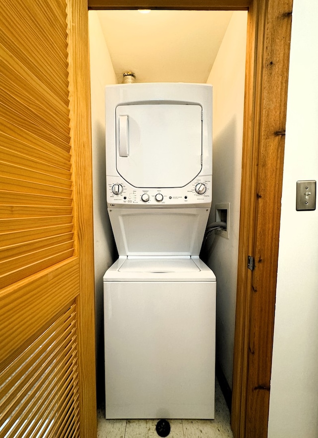 clothes washing area featuring stacked washing maching and dryer