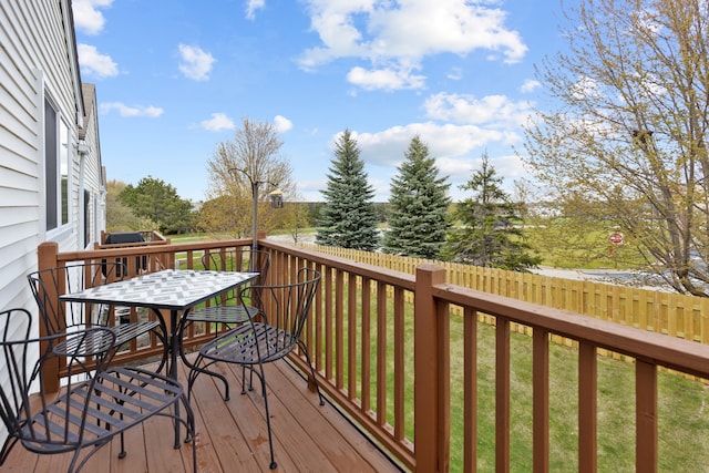 wooden deck featuring a lawn