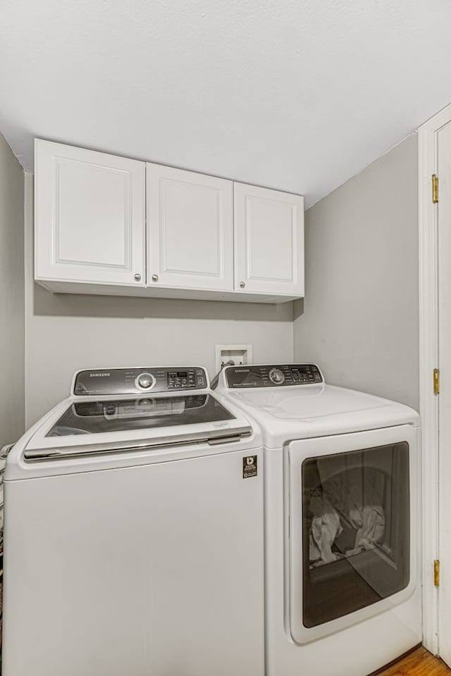 washroom featuring cabinets and washer and dryer