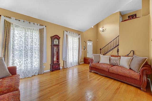 living room featuring light wood-type flooring, an inviting chandelier, and vaulted ceiling