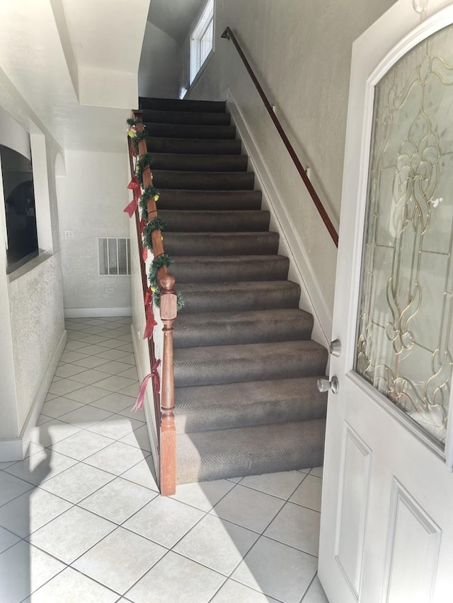 stairs featuring tile patterned flooring