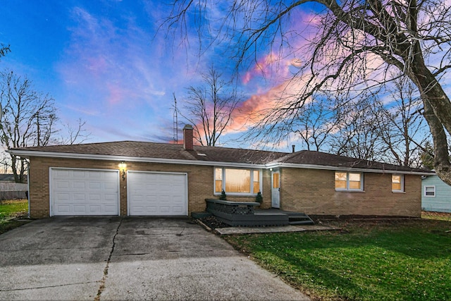 single story home with a lawn and a garage