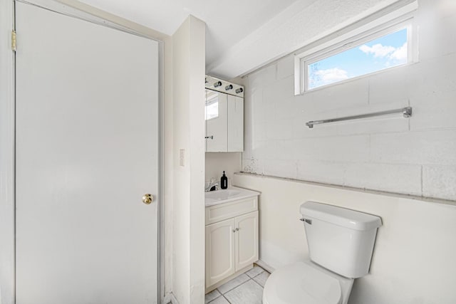 bathroom with toilet, vanity, and tile patterned floors