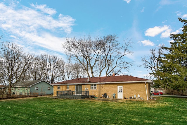 rear view of property featuring a deck and a yard