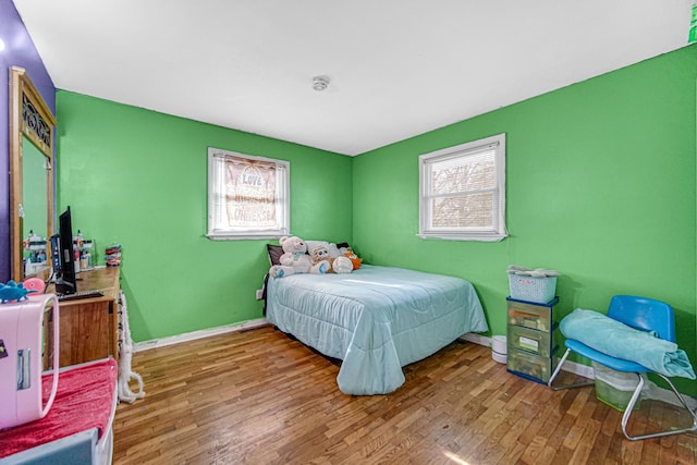 bedroom featuring multiple windows and hardwood / wood-style floors