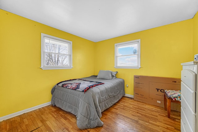 bedroom featuring multiple windows and light hardwood / wood-style flooring