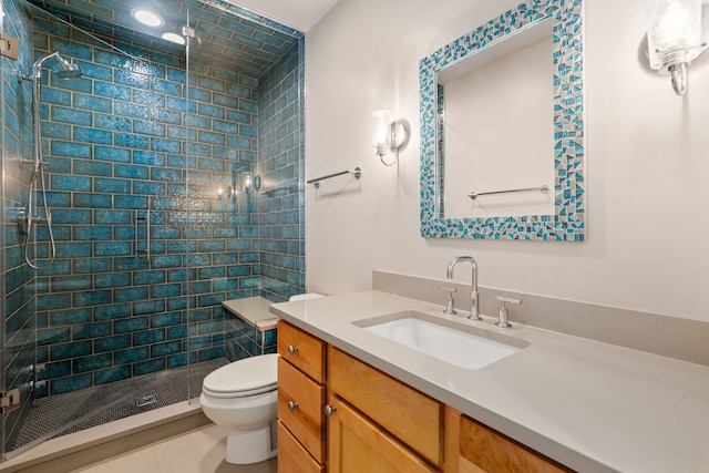 bathroom featuring tiled shower, vanity, and toilet