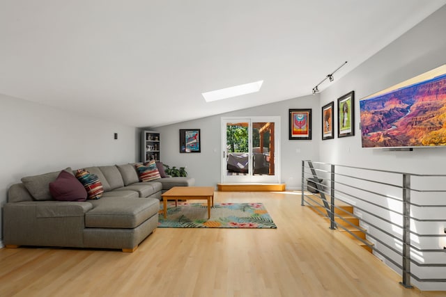 living room featuring hardwood / wood-style floors and lofted ceiling with skylight