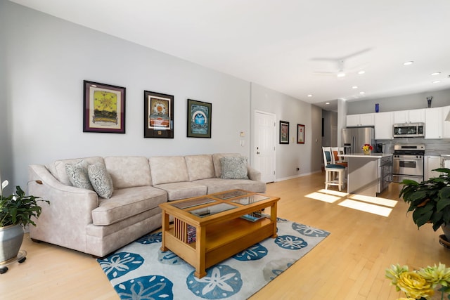 living room featuring light hardwood / wood-style flooring and ceiling fan