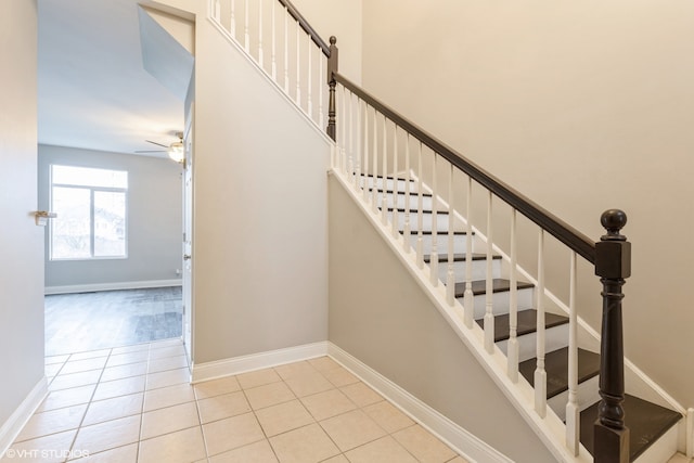 stairs featuring tile patterned flooring and ceiling fan