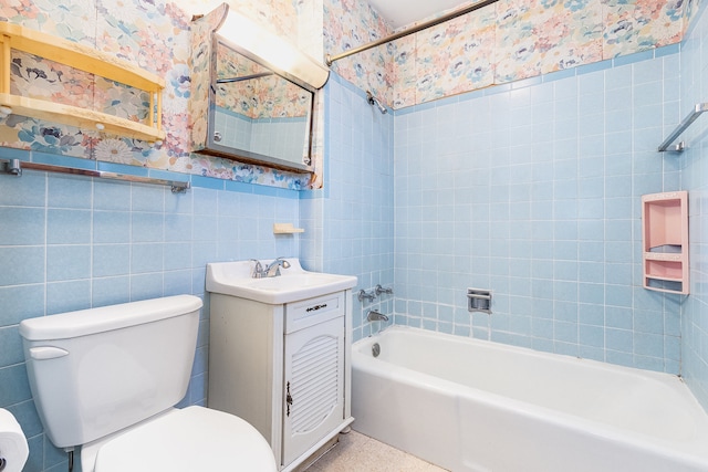 full bathroom with vanity, toilet, tile walls, and tiled shower / bath combo