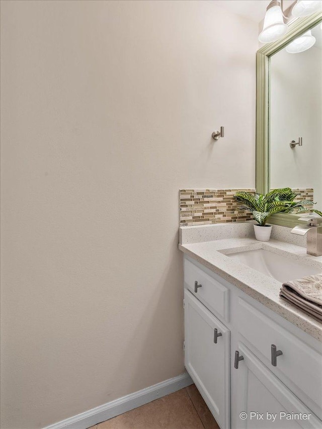 bathroom featuring vanity, tile patterned flooring, and tasteful backsplash