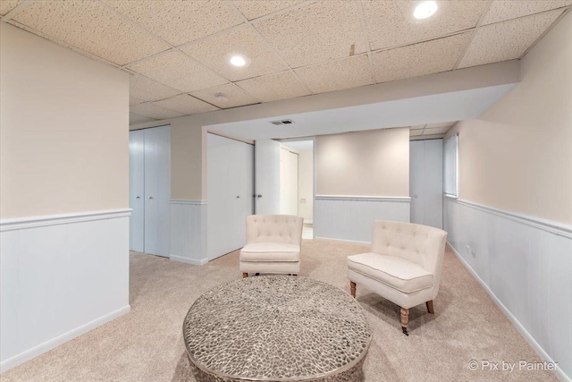 sitting room featuring a paneled ceiling and carpet