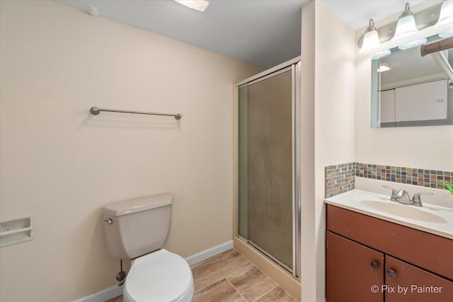 bathroom with a shower with door, vanity, tasteful backsplash, and toilet