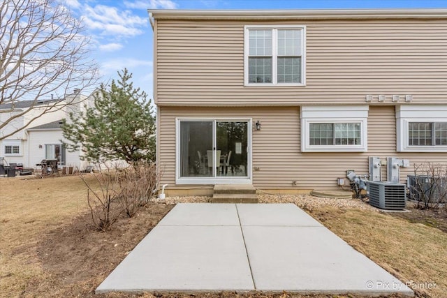 back of property with a patio, central AC, and a lawn