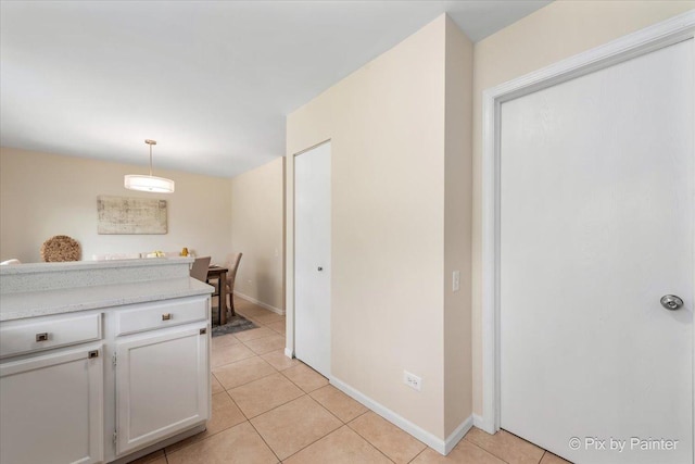 kitchen with white cabinetry, light tile patterned floors, and decorative light fixtures