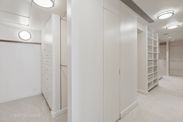 walk in closet featuring light carpet