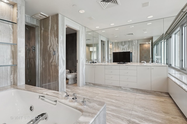 bathroom with a bathtub, vanity, and a bidet