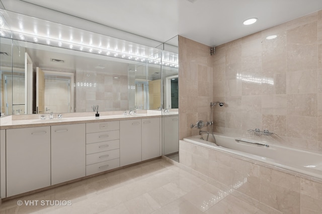 bathroom featuring tiled bath and vanity