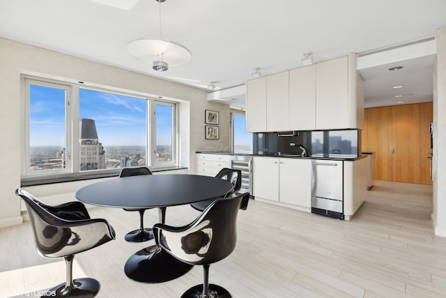 kitchen with pendant lighting, white cabinetry, dishwasher, light hardwood / wood-style floors, and wine cooler