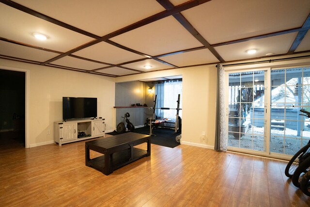 living room with light wood-type flooring, plenty of natural light, and coffered ceiling