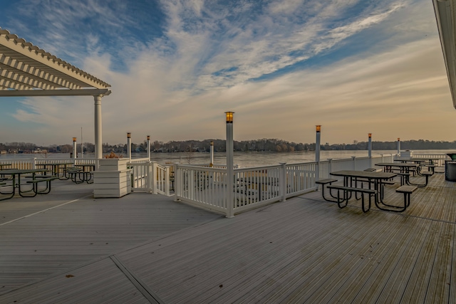 deck at dusk featuring a pergola