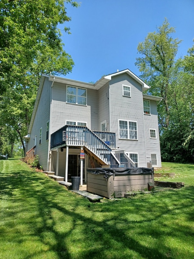 back of property featuring a lawn and a wooden deck