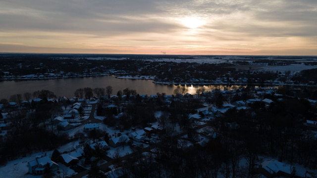 aerial view at dusk featuring a water view