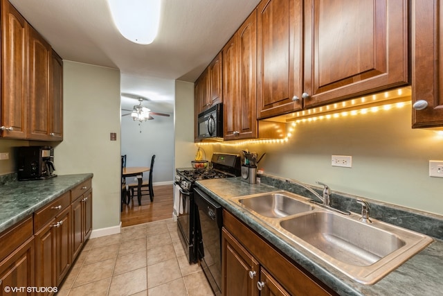 kitchen featuring ceiling fan, sink, light tile patterned floors, and black appliances