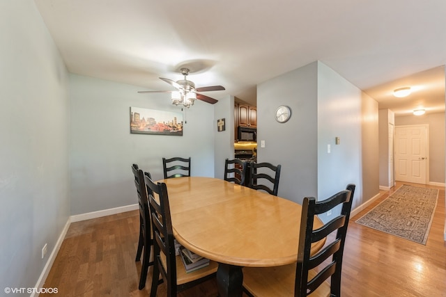 dining space with ceiling fan and wood-type flooring