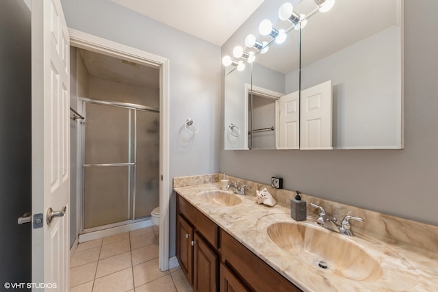 bathroom with tile patterned floors, vanity, an enclosed shower, and toilet