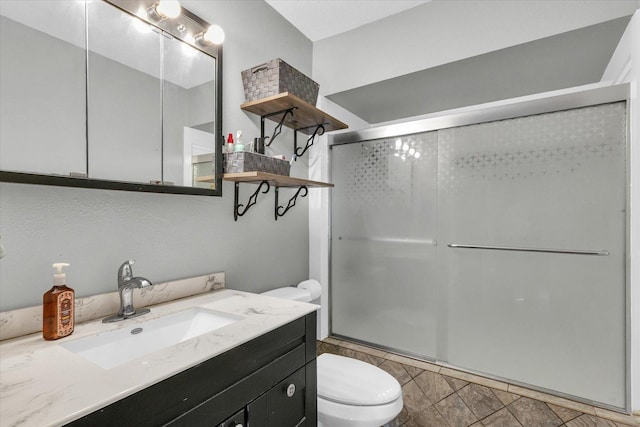 bathroom with toilet, vanity, tile patterned floors, and a shower with shower door