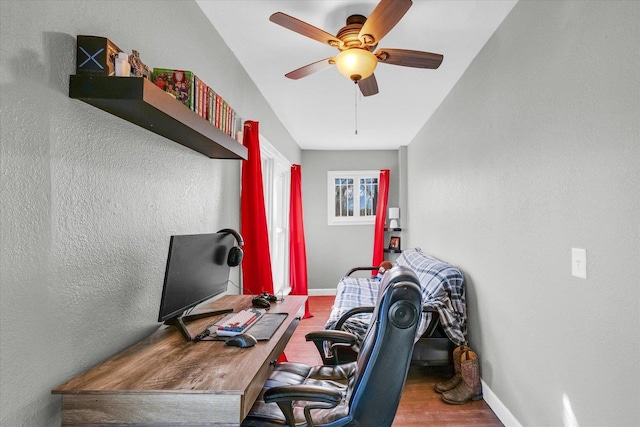 home office with ceiling fan, vaulted ceiling, and hardwood / wood-style flooring