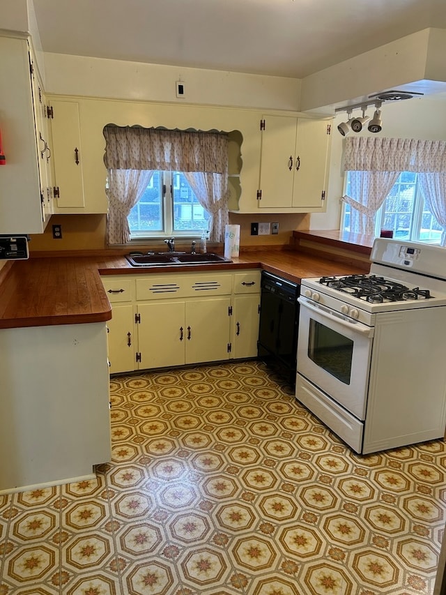 kitchen with white range with gas cooktop, a wealth of natural light, dishwasher, and white cabinets